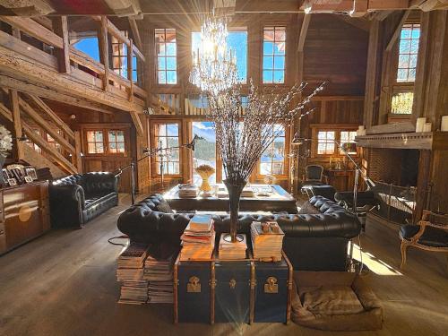 un soggiorno con un divano e un lampadario di Chalet Hermine a Megève