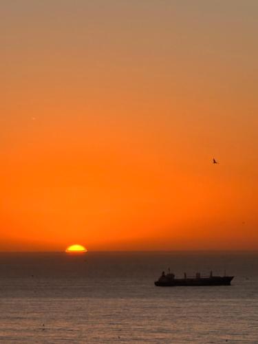 a boat in the ocean at sunset at Tawala House shared dorm room in Agadir