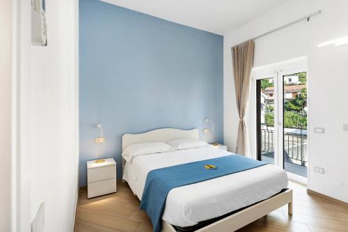 a bedroom with a white bed and a blue wall at Nanninella Guest House in Minori