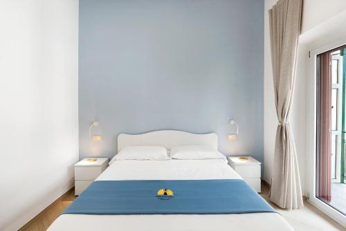 Nanninella Guest House في مينوري: غرفة نوم بسرير والجدران الزرقاء ونافذة