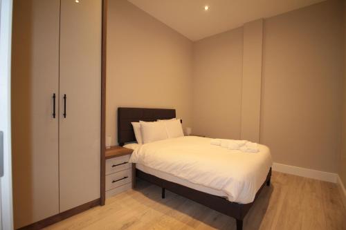 a small bedroom with a bed and a cabinet at One Bedroom Flat With Free parking in Acton in London
