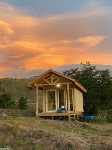 a small house sitting on top of a field at Cabaña Caiquen in Villa Cerro Castillo