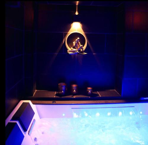 Work in spa في فوارون: حمام مع حوض استحمام مع إضاءة فوقه