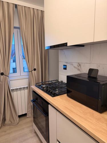 uma cozinha com fogão forno superior ao lado de uma janela em Sage Studio em Drobeta-Turnu Severin