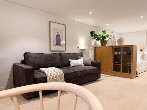 Una sala de estar con un sofá negro y un armario. en New modern apartment, en Bergen
