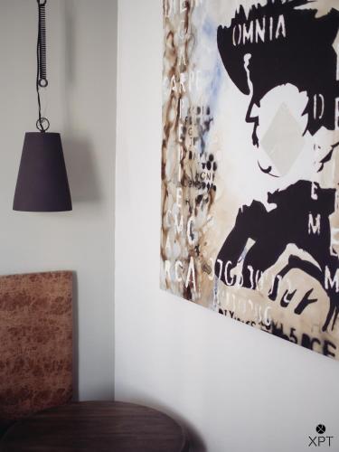 a wall with a painting on it next to a chair at XPT Águeda - Alojamento Local in Águeda
