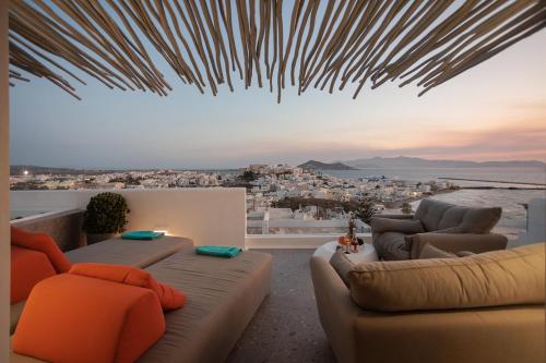 a living room with couches and a view of a city at HIGH END Unique 270 degree aerial sea view suite in Naxos Chora