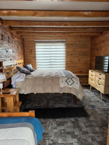 a bedroom with a bed in a log cabin at Cabañas El Quincho de Putú in Constitución