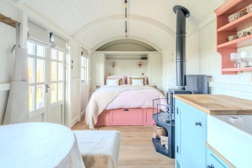 a bedroom with a bed with a pink blanket at Red Robin Retreat in Broadway