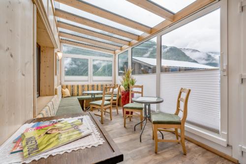 LYNS HOME في سولدن: غرفة بها طاولة وكراسي ونافذة كبيرة