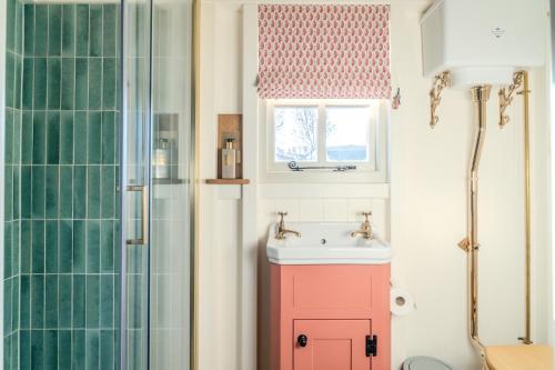 a bathroom with a pink cabinet and a sink at Red Robin Retreat in Broadway