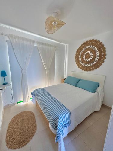 a bedroom with a large bed with blue pillows at Terraza al mar in Candelaria