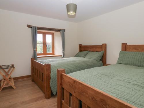 a bedroom with two twin beds and a window at Howgill Head in Kendal