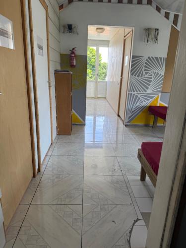 Un pasillo con suelo de baldosas y una puerta. en Dortoir 1, en Faaa