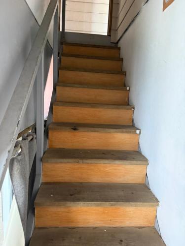 Una escalera en una casa con escalones de madera en Dortoir 1, en Faaa