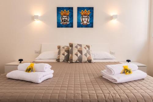 una camera da letto con un letto con asciugamani sopra di Terrazza in Centro - Casa Torres ad Acireale
