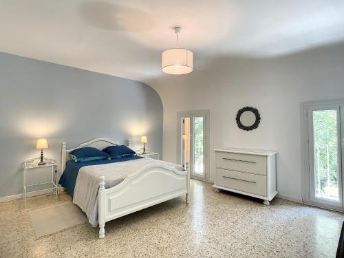 Un dormitorio con una cama blanca con almohadas azules. en Quai n16 - Lieu atypique pour un séjour au calme, en Aramon