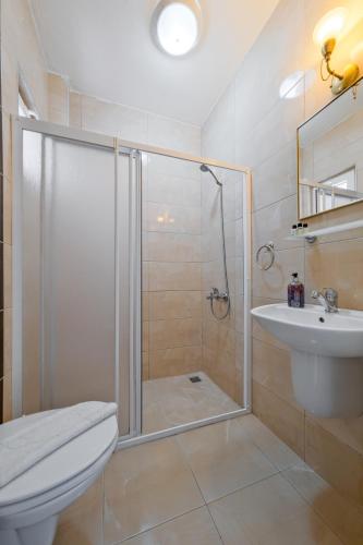a bathroom with a shower and a toilet and a sink at YENI DOGA HOTEL in Dalyan