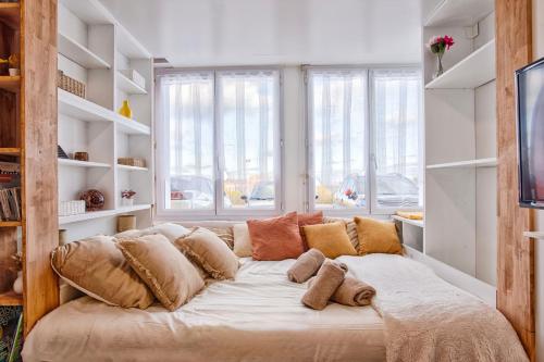 Front de mer - Studio RDC - Centre-ville & Casino في لوك-سور-مير: سرير كبير مع وسائد في غرفة مع نوافذ