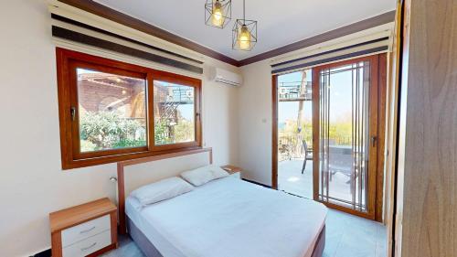 a bedroom with a bed and two windows and a balcony at Villa Dunya in Kyrenia