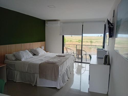 a bedroom with a bed with a green wall at PLC Hotel Centenario in Paso de los Toros