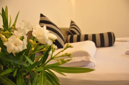 a vase with white flowers on a bed with pillows at Green Villa Unawatuna in Unawatuna
