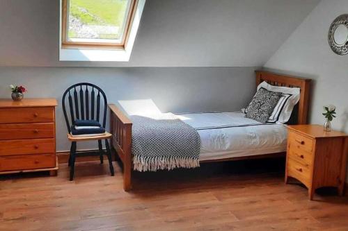 a bedroom with a bed and a chair and a desk at Tranquil Retreat at Ailt Cottage in Dunfanaghy