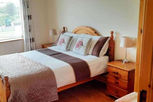 a bedroom with a large bed and a window at Tranquil Retreat at Ailt Cottage in Dunfanaghy