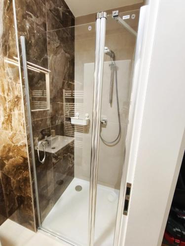 a shower with a glass door in a bathroom at Diamond Apartment Brno in Brno