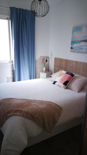 a bedroom with a large white bed with pillows at 25 Atardeceres in El Paso