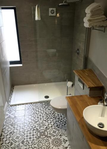 a bathroom with a tub and a sink at Billycan in Tenby