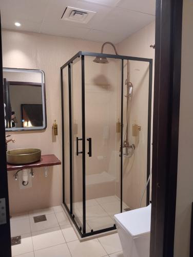 a bathroom with a glass shower and a sink at Ahmadia Heritage Hiba Guest House - Built in 1916 - Al Ras Metro Station in Dubai