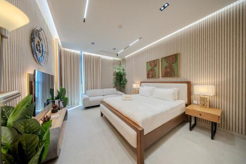 a bedroom with a large bed and a couch at Amazing Studio in Areej Aljada in Sharjah