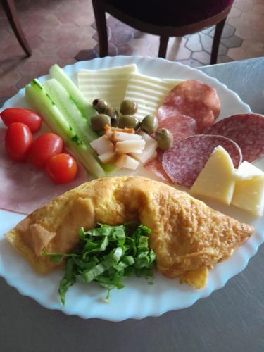 een bord met vleeskaas en groenten bij Vila Kira Buşteni in Buşteni