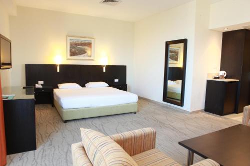 a hotel room with a bed and a table and chairs at Ein Kerem Hotel in Jerusalem