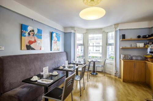 una sala de estar con un sofá, una mesa y sillas en Brightonwave, en Brighton & Hove