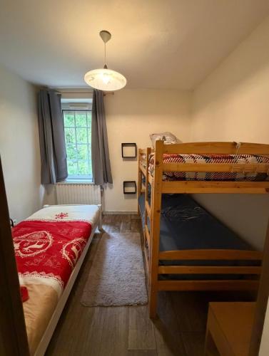 Appartement La Vanne Confortable et équipé في لابريس: غرفة نوم بها سريرين بطابقين ونافذة