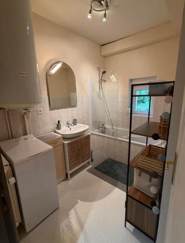 Appartement La Vanne Confortable et équipé في لابريس: حمام صغير مع حوض وحوض ومغسلة
