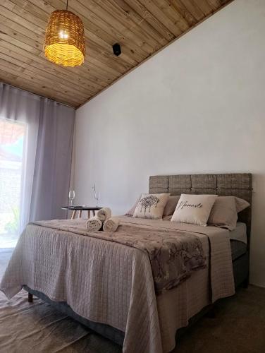 a bedroom with a large bed with a wooden ceiling at Vila Mar Lofts in Barra Velha