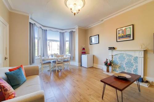 a living room with a couch and a table at Comfortable Ealing Apartment with Workspace in London