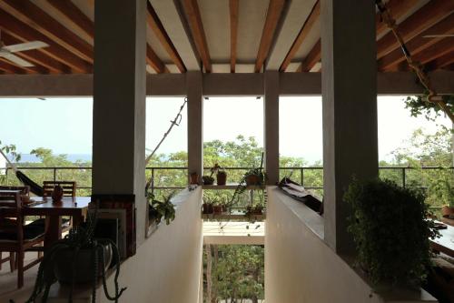 Habitación con balcón con mesa y algunas plantas. en Villa Cuachalalate - Puerto Escondido, en El Puertecito