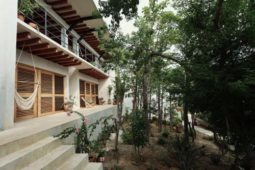 una casa con escaleras y árboles delante de ella en Villa Cuachalalate - Puerto Escondido, en El Puertecito