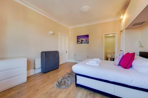 a bedroom with a bed and a tv in it at Comfortable Ealing Apartment with Workspace in London