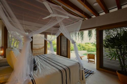 Villa Cuachalalate - Puerto Escondido في El Puertecito: غرفة نوم بسرير مع ناموسية