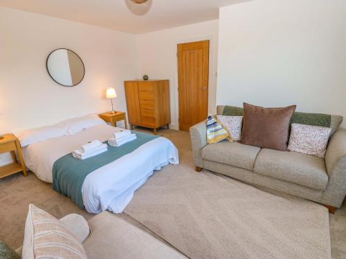 a bedroom with a bed and a couch at Mains Cottage in Consett