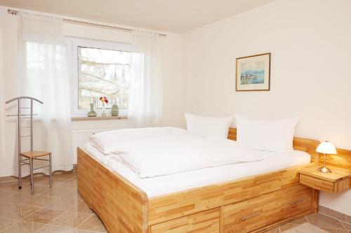 Schlafzimmer mit einem Bett mit weißer Bettwäsche und einem Fenster in der Unterkunft Ferienwohnung Ewers in Oberstdorf