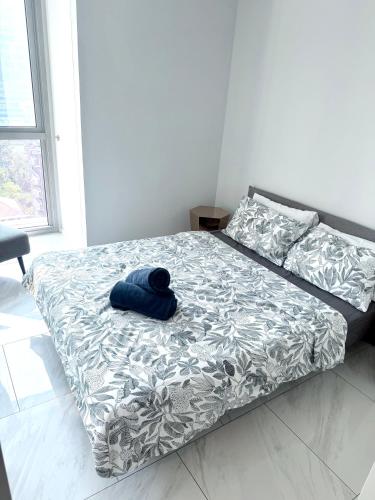 a bed with a blue hat on it in a room at Stylish Luxury 1 Bedroom, Hyde Sukhumvit 11, Near BTS Nana & Asok in Bangkok