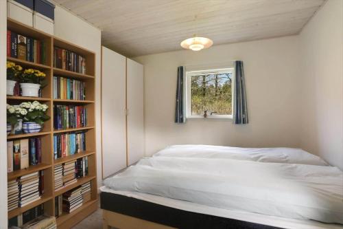 una camera con letto, finestra e librerie di LK2197-Lokken-Molleager-1 a Lyngbytorp