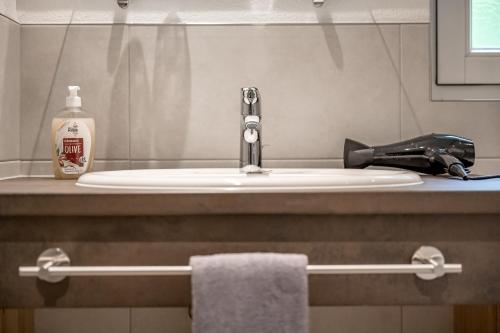 a bathroom sink with a hair dryer and a phone at LYNS HOME in Sölden