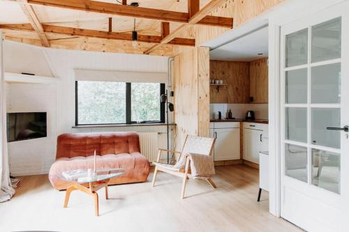 a living room with a couch and a table at Boshuisje Noi op de Veluwe in Hattemerbroek